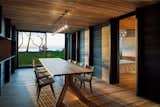 Dining Room, Chair, Table, Ceiling Lighting, Pendant Lighting, and Light Hardwood Floor The dining space, with glass on one end, connects the sleeping quarts with the main living spaces.  Photo 8 of 12 in A Dramatic Cantilevered Roof Creates a Spacious Terrace Overlooking Lake Michigan