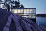 Set at the edge of Stoney Lake in Ontario, Canada, is a photographer's home, studio, and boat house designed by Toronto-based studio GH3. The glass box unites landscape and architecture while providing ideal spaces for photography, programmatic functions for living, and boat storage.