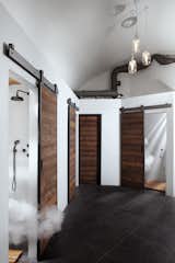Sliding wood barn doors conceal shower rooms.