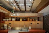 Open shelving continues into the kitchen.  A wood-framed skylight above draws natural light into the space.