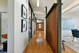 Hallway and Medium Hardwood Floor The central gallery, framed by wood screen walls on both sides, links the main living spaces.  The partitions create a more open, expansive volume.  Photo 5 of 14 in A Bay Area Jewel With Golden Gate Views Wants $1.55M