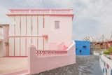 Outdoor, Concrete Fences, Wall, Hardscapes, and Front Yard Pink rock salt covers the exterior patio.   Photos from These Pink and Blue Homes Use Gender as a Metaphor For Urban Revitalization