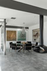 Dining Room, Concrete Floor, Chair, Hanging Fireplace, Table, and Ceiling Lighting Modern furnishings, a decorative metallic pendant, and colorful artwork decorate the dining space.  Photo 3 of 8 in 7 Effortless Ways to Infuse Metallics Into Your Home from The Last Donald Wexler–Designed Home Ever Built Asks $2.65M