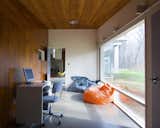 The children's playroom sits off one end of the living space, adjacent to the kitchen and children's bedroom.  Full-height windows look south onto the tree-covered land. 