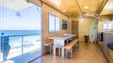 Dining Room, Table, Stools, Bench, Ceiling Lighting, and Light Hardwood Floor Large sliding glass doors draw in plenty of daylight while providing beachfront access.  Photo 8 of 11 in Get Your Surf On in This Traveling Truck Hotel