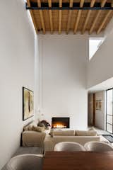 Living Room, Standard Layout Fireplace, Pendant Lighting, and Sofa Wasted space and inefficient uses of rooms and circulation are objectively undesirable.  Photos from Muted Tones Mingle With Light and Shadows to Form a Quiet Mexican Oasis