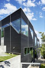 Exterior, House Building Type, and Wood Siding Material As you can see, the home follows the slope of the land. Geometric punched window openings draw in plentiful daylight.

  Photo 2 of 7 in A Contemporary Home Cascades Down the Hillside in Vancouver