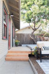 Outdoor, Trees, Wood, Back Yard, Wood, Hardscapes, Small, Decking, Vertical, and Concrete The existing deck was extended to allow access from the master bedroom to rear yard.  Outdoor Back Yard Vertical Hardscapes Small Photos from Budget Breakdown: A San Diego Couple Make Over Their Craftsman Bedroom For $29K