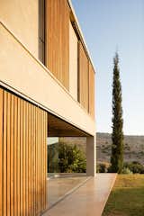 Exterior, House Building Type, Wood Siding Material, Flat RoofLine, and Stucco Siding Material The home is quietly set on the landscape as it reaches out toward both the hills and horizon.

  Photo 14 of 14 in Moveable Wooden Screens Add a Playful Touch to This Airy Home in Israel