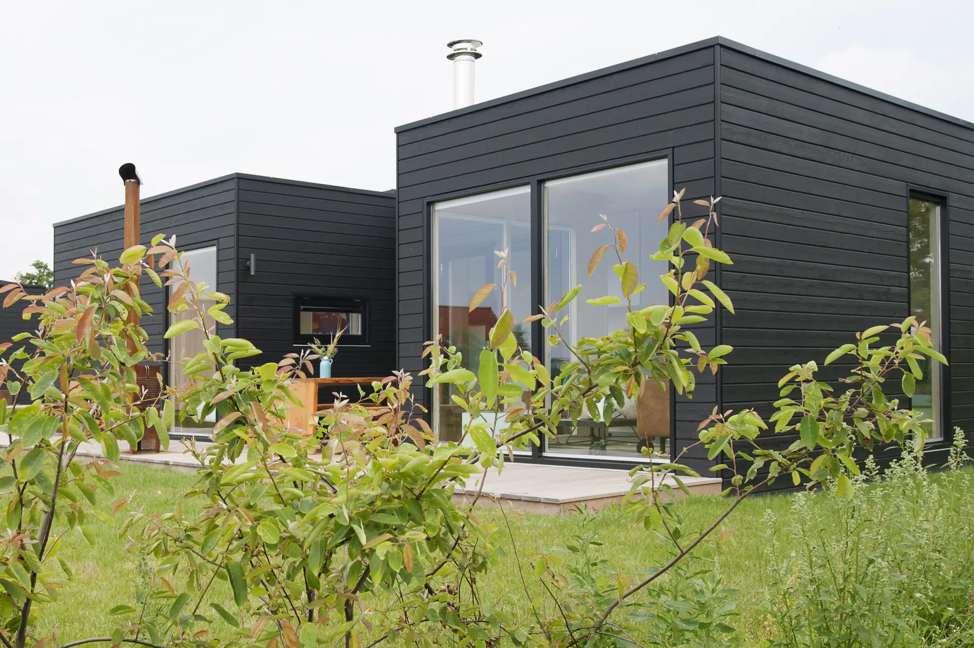 Clad in black-washed decking, the simple structure makes a quiet statement in the natural setting. While its thoughtful layout provides plenty of space for family gatherings, the cabin is also an idyllic setting for a private hideaway.