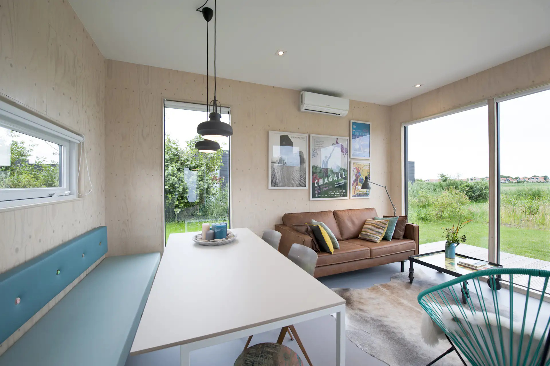 A large dining table with a built-in banquette can comfortably seat an entire family, as well as a group of friends. Bright colors add a nice spark to the otherwise neutral palette.