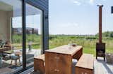 An outdoor picnic table provides a quaint spot to enjoy dinner as a family, play games, or read a book while taking in the village and surrounding scenic views.

  Photo 4 of 16 in This Chic Cabin Makes Glamping in The Netherlands a Breeze from De Grote Beer