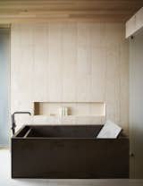 The rough texture of the tiled walls adds a natural element to the refined, elegant bath.&nbsp;&nbsp;