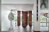 Upon entry, one passes over a bridge, immediately revealing the vertical and open nature of the home from above to below.