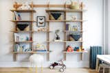 Custom built-in wood shelving adorns the playroom, providing a unique way to display books and toys.