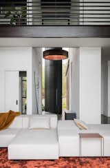 Living Room, Sofa, End Tables, and Rug Floor A 15-ft tall steel, pivot entry door opens onto a combined art gallery and living space.   Photo 3 of 20 in Geremia Design Imbues an Olson Kundig Retreat With Warm Tones and Modern Art from False Bay Home and Writer's Cabin