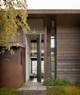 Olson Kundig's natural and warm architectural palette combines metal, wood, and concrete, set against the blues and greens of the lush surroundings and bay. 