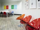 Bold colors in classic, modern furnishings create a fun work environment.  Red and orange Kartell chairs, Modway dining chairs, and a stylish Ping Pong table by RS Barcelona combine to create an energetic, multi-functional space. 