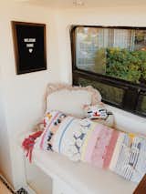 A lucky cat pillow from Urban Outfitters and a striped body pillow introduce color and personal style into the space.