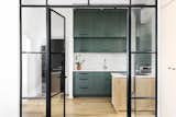 From the bedroom, glass and iron doors reveal the open kitchen space. Although unconventional for privacy, the glass doors enhance the feeling of an open plan. 