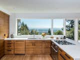 A large picture window provides endless views of the Cascade Mountains from this contemporary, open kitchen.&nbsp;