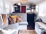 The front of the bus has an open-concept layout with compact living, kitchen, and dining areas. For added flexibility, the couch turns into a bed and a dining table. The back of the bus features cozy sleeping areas, storage, a bathroom, and a standing desk for remote working.