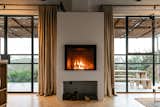 The fireplace is the focal piece of the living area, anchored by glazed openings on either side. 