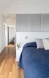 Perforated metal screens connect design elements in the upstairs to the main floor below.&nbsp; A built-in headboard provides clothes storage on one side, and nightstands on the other.&nbsp;