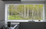 In the kitchen, a large picture window frames views of the surrounding forested land. 