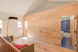 On the second floor, the wood-clad volume conceals two bedrooms and a bathroom.