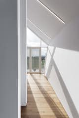 Wood planks and thin ceiling-mounted lights create a linear pattern which draws the eye outward. 