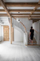 The interior staircase is an elegant contrast with its curved form. Wood stair treads and a wood railing lead to the sleeping and bathing quarters above.&nbsp;