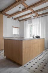 The floor tiles in the kitchen date back to 1923 and stand as a reminder of the original character of the building. Natural oak cabinets with hidden joinery are a contemporary insertion in the historic building shell. 