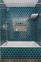Geometric teal Gotham Swiss Cross tiles by Ann Sacks add playfulness and color to the basement bath. 
