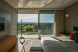 Bedroom, Wall Lighting, Dresser, Bed, and Night Stands Located on the upper floor, stacked above the main living spaces, each sleeping room has its own exquisite views of the surrounding hills.  Photo 6 of 13 in This Surprisingly Airy Holiday Home Is Made of Massive Concrete Slabs