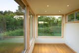 The Glass Studio lets the exterior in with full views to the surroundings. On the interior drywall, maple trim, and a maple floor complete the space. 