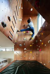 The homeowner trains on the climbing wall, which features a 15-degree slope on one face, expert-level climbing holds, and a crash pad.