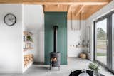 A wood-burning fireplace is the heart of the living room, set off by a stacked tile wall in a soft green hue. 
