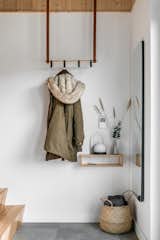 A simple suspended coat hanger provides additional storage for outdoor and cold weather gear. 