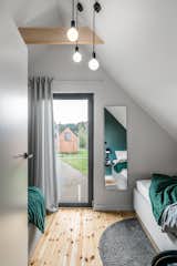 One of the two bedrooms includes two smaller beds. A glass door opens to a small Juliet balcony with a glass rail. 