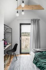 The second of the two bedrooms includes a double bed and desk area. Similarly, the glass door can be opened to further connect the sleeping space to the outdoors. 
