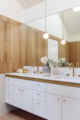 Thin, slatted wood paneling adds warmth to this bathroom.