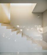 A white, geometric stair is a bright contrast to the black exterior.&nbsp;