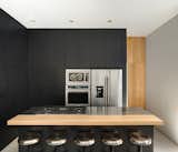 Lluvia by PPAA black kitchen with stainless steel and wood accents