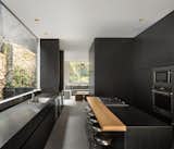 Lluvia by PPAA black kitchen with stainless-steel countertops