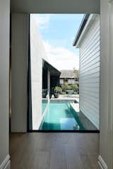 A large floor-to-ceiling window provides uninterrupted views to the rear garden and lap pool, while visually marking the transition from old to new. 