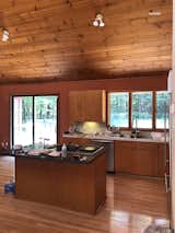 Before: At designer Sarah Sherman Samuel’s Michigan home, the sloped wood ceiling in the kitchen was getting lost against the wood floors, wood cabinetry, and dark walls.