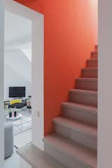 Orange Aurora walls edged in crisp white lend a striking effect to the staircase leading to the upper floor. Minimizing this bold color intervention to a small area allows the stair to serve as a focal point without overwhelming the design.