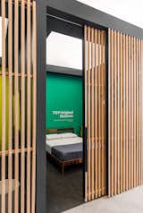 In the Tuft &amp; Needle store by Hufft, semi-private rooms allows guests to comfortably test inventory. Vertical wood screens provide privacy in this showroom like space which embraces the comfort of home with a residential feel.