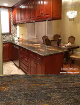 This kitchen design features Orion granite countertops. 

Orion granite has a medium-grain with circular movements, warm brown color shades and some golden intrusions. 

More info here: http://www.egmcorp.com/granite/orion